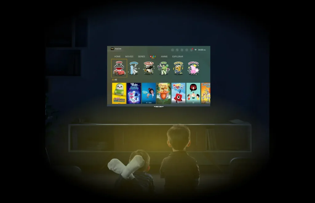 A boy sitting on a couch, watching a movie on the Youcine, with popcorn beside her and a television in view.